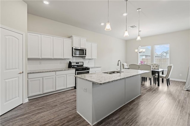 kitchen featuring white cabinetry, sink, stainless steel appliances, and hanging light fixtures