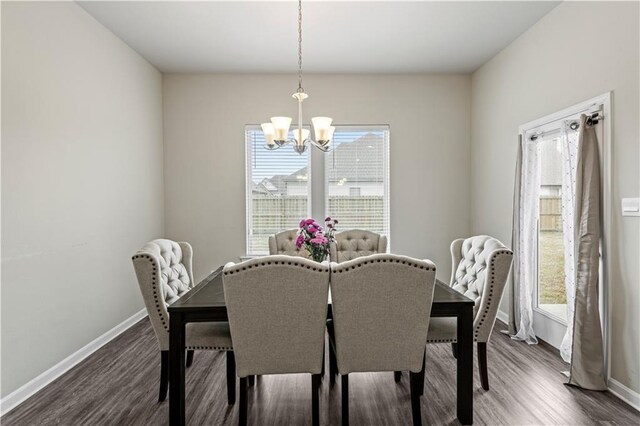 dining area with a healthy amount of sunlight, a chandelier, and dark hardwood / wood-style flooring