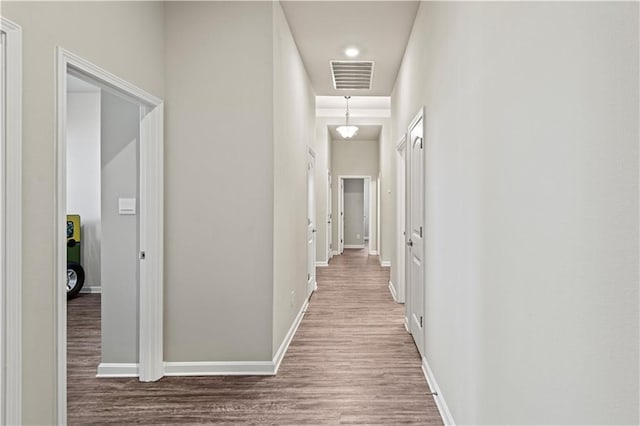 corridor with hardwood / wood-style flooring