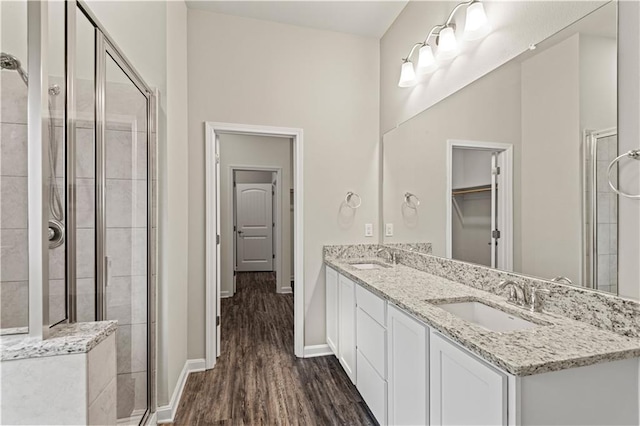 bathroom with wood-type flooring, an enclosed shower, and vanity