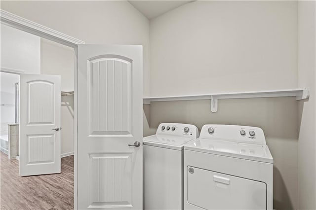 washroom featuring separate washer and dryer and light hardwood / wood-style flooring