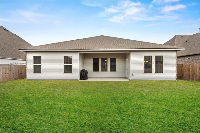 back of house featuring a patio area and a lawn