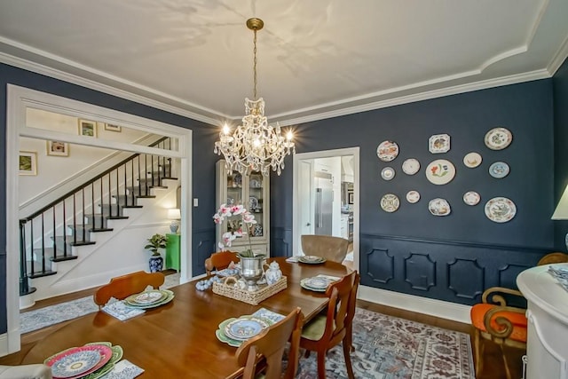 dining area featuring a notable chandelier, wood-type flooring, and ornamental molding