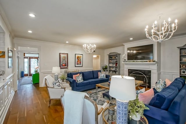 living room featuring hardwood / wood-style flooring, ornamental molding, and a chandelier