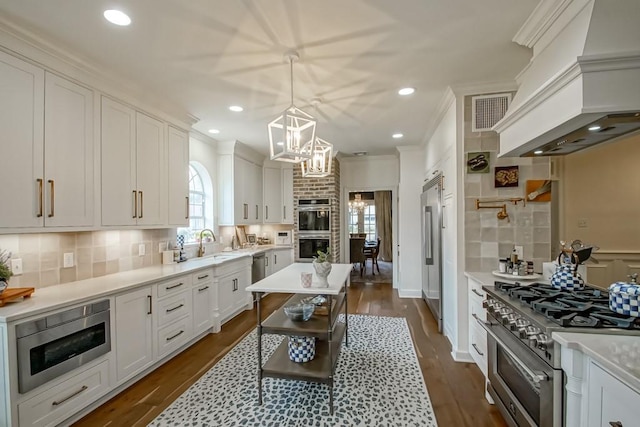 kitchen featuring white cabinetry, high quality appliances, custom range hood, pendant lighting, and decorative backsplash