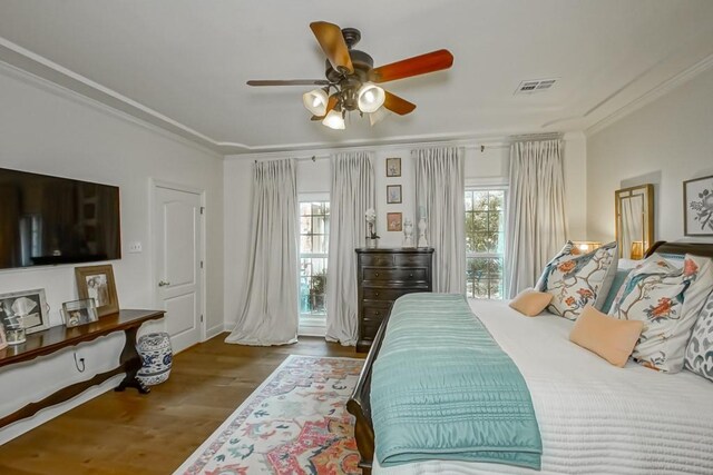 bedroom with crown molding, ceiling fan, and dark wood-type flooring