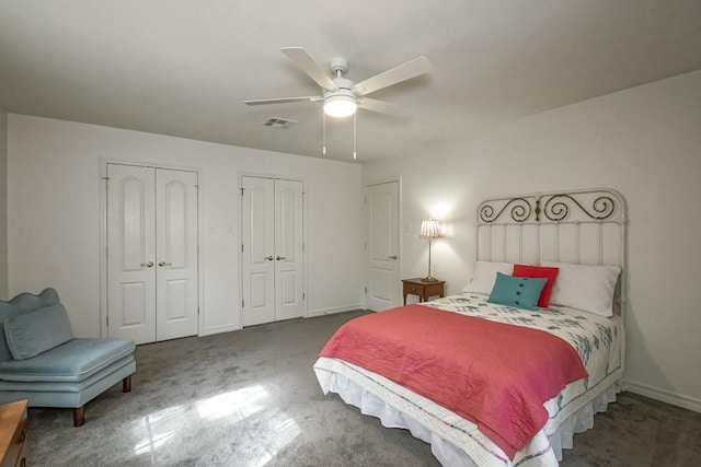 carpeted bedroom featuring ceiling fan and multiple closets