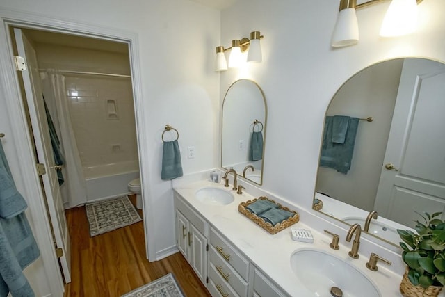 full bathroom featuring wood-type flooring, shower / bath combo, vanity, and toilet