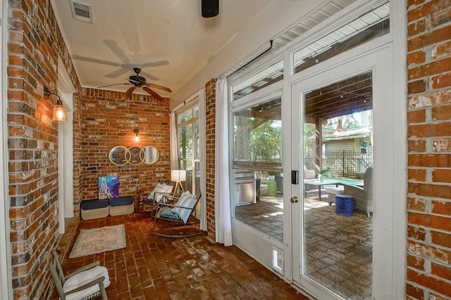 unfurnished sunroom featuring ceiling fan