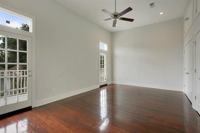 unfurnished room featuring dark wood-type flooring, plenty of natural light, and ceiling fan