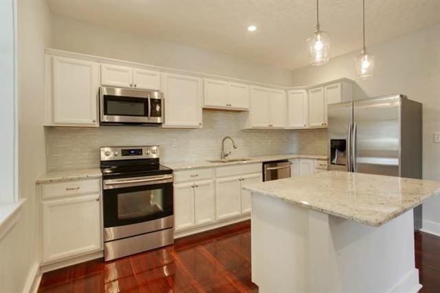 kitchen featuring white cabinetry, sink, a kitchen island, and appliances with stainless steel finishes