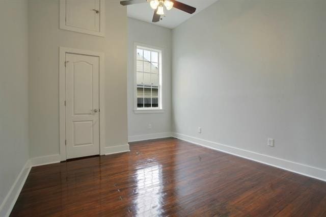 spare room with dark wood-type flooring and ceiling fan