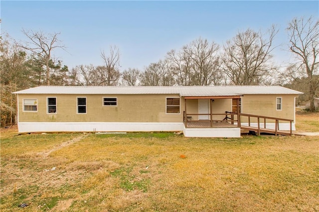 back of property with a lawn and a deck