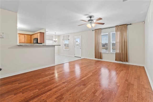 unfurnished living room with light hardwood / wood-style flooring, plenty of natural light, and ceiling fan