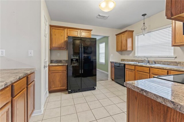 kitchen featuring pendant lighting, sink, light tile patterned floors, and black appliances