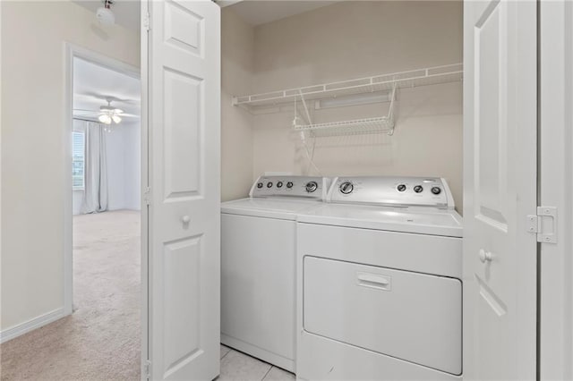 laundry area with ceiling fan, washing machine and clothes dryer, and light carpet