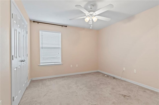 carpeted empty room featuring ceiling fan