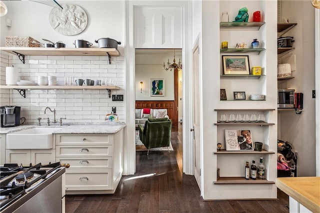 interior space featuring sink, dark hardwood / wood-style flooring, white cabinets, light stone countertops, and backsplash