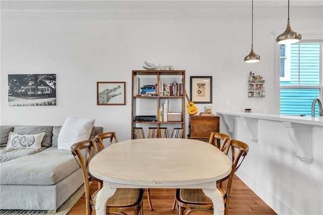 dining area with crown molding and wood-type flooring