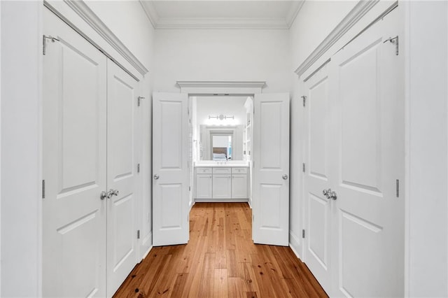 corridor featuring ornamental molding and light hardwood / wood-style floors