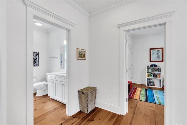 hall with crown molding and light hardwood / wood-style floors