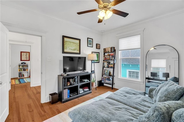 living room featuring crown molding, ceiling fan, and light hardwood / wood-style floors