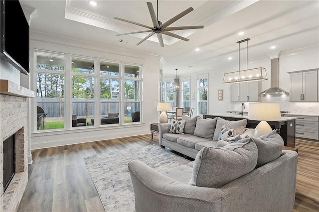 living room with dark hardwood / wood-style flooring, a brick fireplace, and crown molding