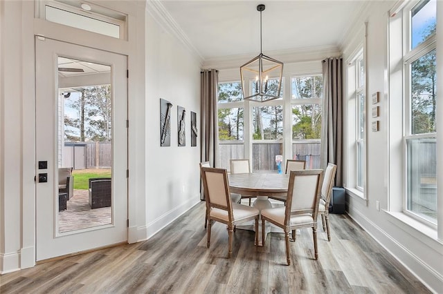 sunroom / solarium with plenty of natural light and an inviting chandelier