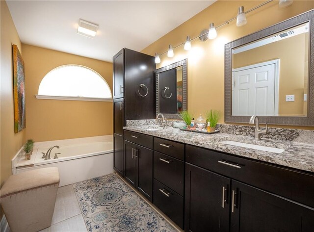 bathroom featuring vanity, tile patterned floors, and a bathing tub