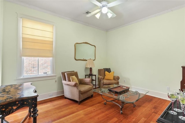 living area featuring ceiling fan, ornamental molding, and light hardwood / wood-style flooring