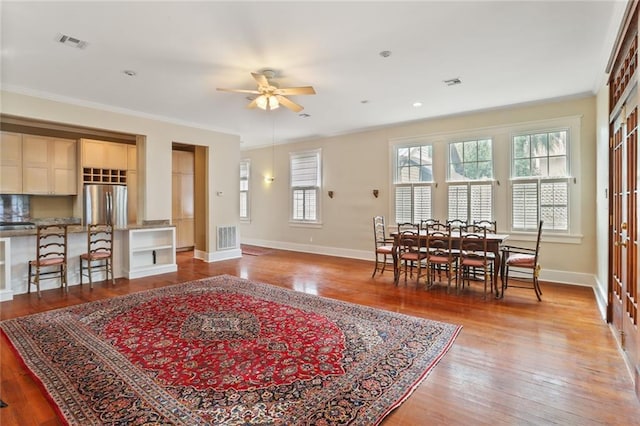 living room with ceiling fan, ornamental molding, wood-type flooring, and a wealth of natural light