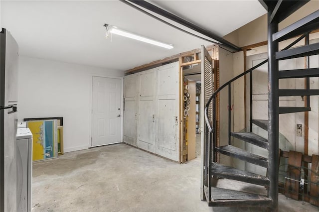 basement with washer / clothes dryer and stainless steel fridge