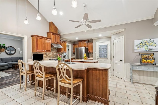 kitchen with stainless steel fridge, a kitchen breakfast bar, hanging light fixtures, light tile patterned floors, and crown molding