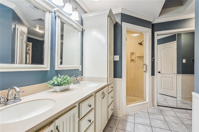 bathroom with tile patterned flooring, ornamental molding, vanity, and walk in shower