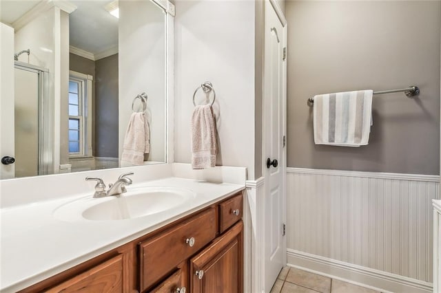 bathroom featuring tile patterned flooring, vanity, ornamental molding, and a shower with shower door