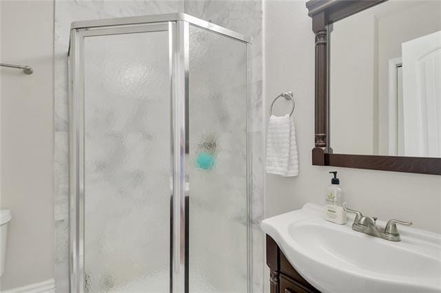 bathroom with vanity, toilet, and a shower with shower door