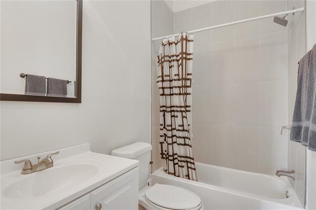 full bathroom featuring vanity, shower / bath combination with curtain, and toilet