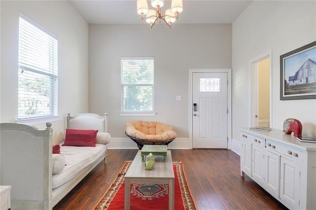 living room with dark hardwood / wood-style floors, a wealth of natural light, and a chandelier