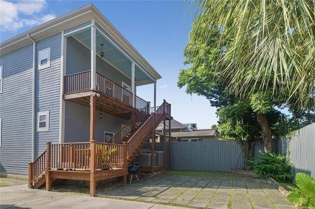 rear view of property featuring a wooden deck and a patio area