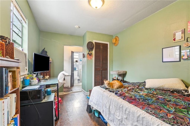 bedroom with dark hardwood / wood-style flooring and a closet