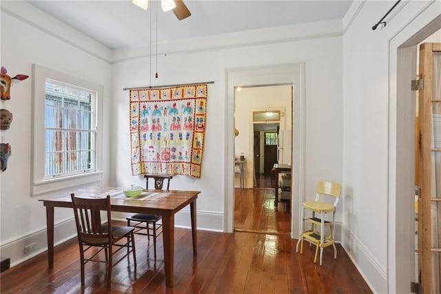 dining area featuring dark wood-type flooring and ceiling fan