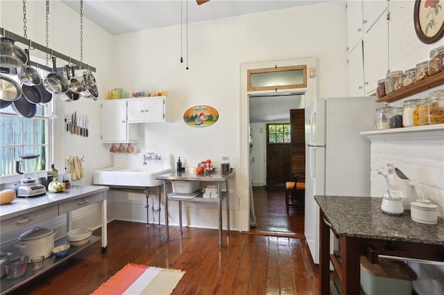 kitchen featuring white cabinetry, white fridge, dark wood-type flooring, and sink