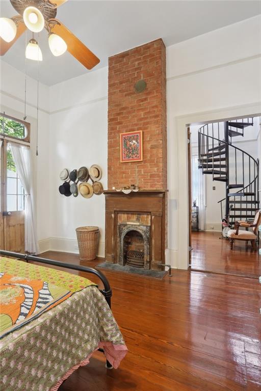 bedroom with wood-type flooring and a fireplace