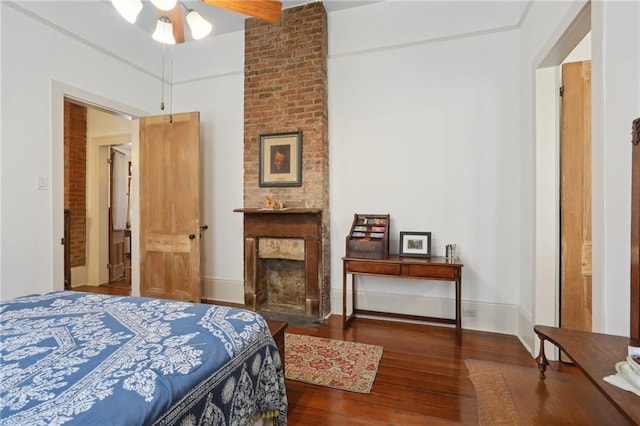 bedroom with a fireplace and dark hardwood / wood-style floors