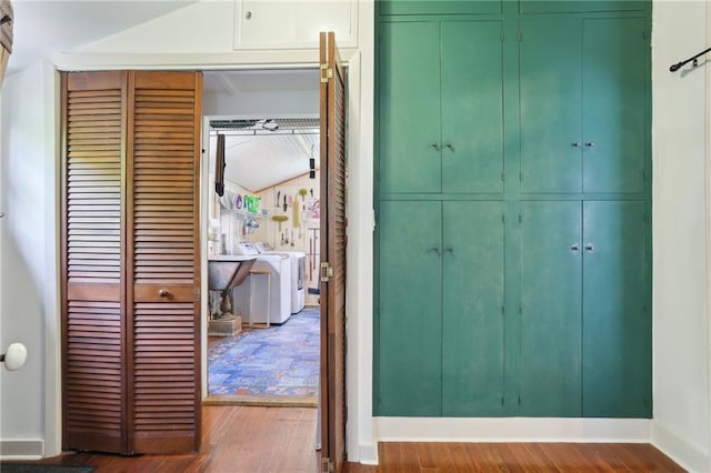 hallway with dark wood-type flooring and washer / dryer