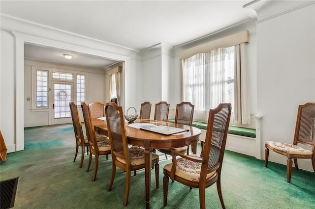 carpeted dining room featuring visible vents and crown molding