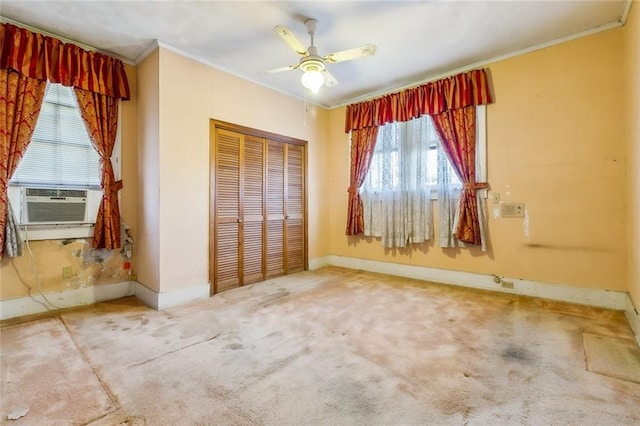 unfurnished bedroom featuring baseboards, ornamental molding, carpet, cooling unit, and a closet