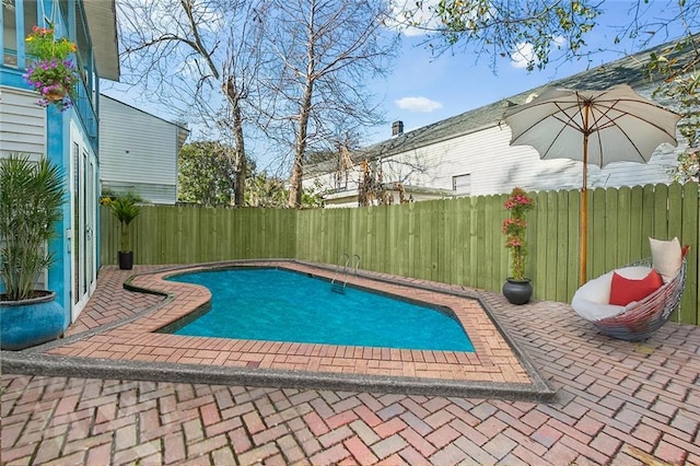 view of swimming pool with a fenced backyard, a fenced in pool, and a patio