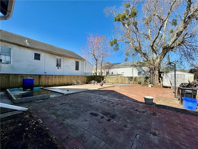 view of yard featuring an outbuilding, a patio area, and fence