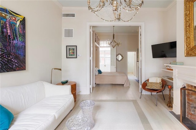 living room with crown molding, a chandelier, and light wood-type flooring